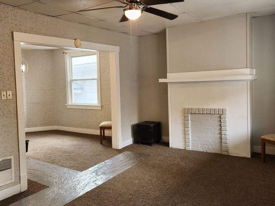 Livingroom with decorative fireplace open to diningroom