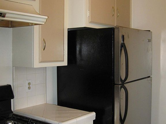 Kitchen with stainless steel stove and refrigerator.
