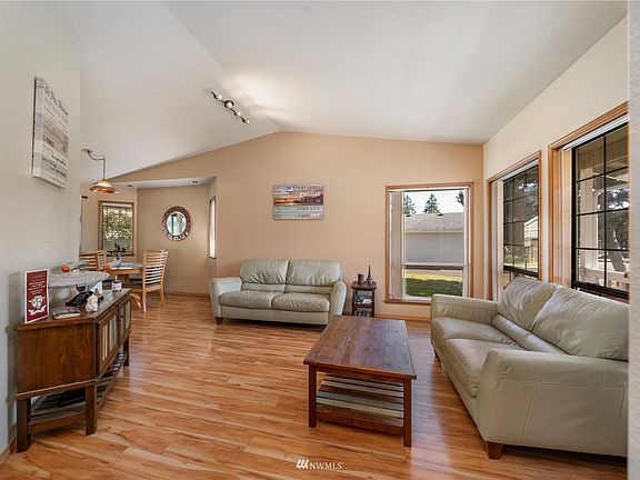 Living Room off the Entry is on the main floor of this home. With vaulted ceilings and huge windows, this room has so much natural light!