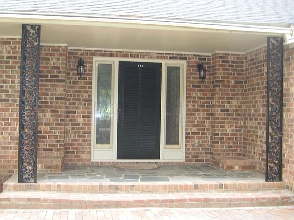Front pront and entry with intricate ironwork and leaded glass