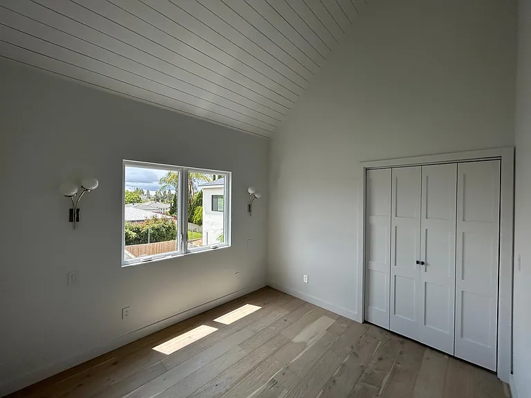 Bedroom with oversized windows high ceilings and walk-in closet