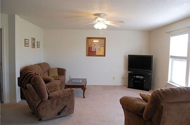 Huge 17x15 family room with ceiling fan and lots of light.