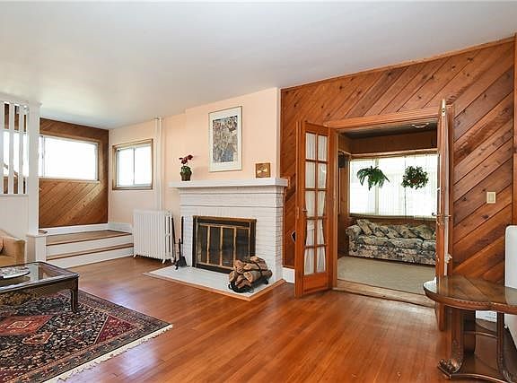 Living room has wood burning fireplace and French doors to family room