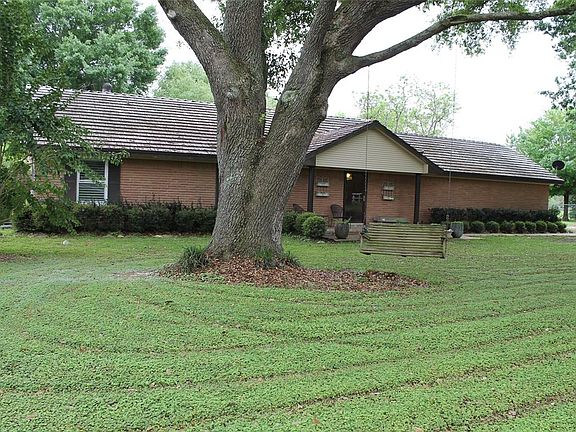 Picture yourself swinging on this bench in this spacious front yard.