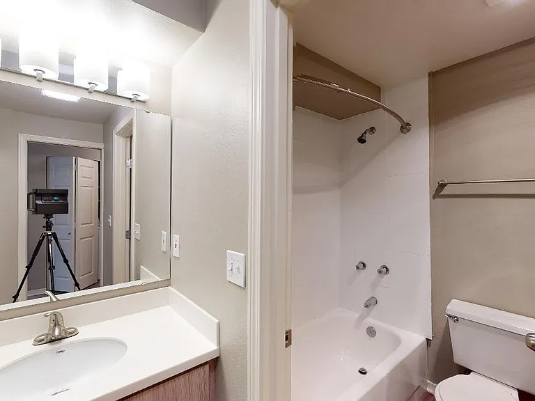Apartment bathroom with wood-style flooring.