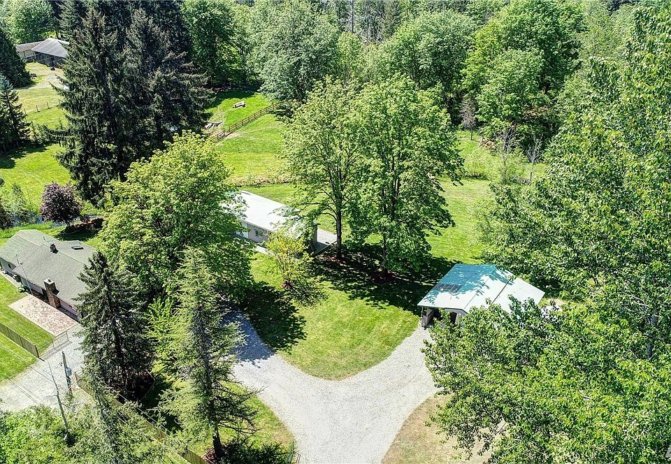 3.6 Captivating acres! Pond with fishing dock on the left, small tributary from Shadow Lake. 2 bed rambler plus detached studio/shop/garage. Huge 3 tier carport with covered sitting or eating area. Beautiful park setting with mini stable above and a section of woods to the far right with bike or walking trails that circle around! Lots of space and fully fenced and gated. Park like setting, many uses for this property!