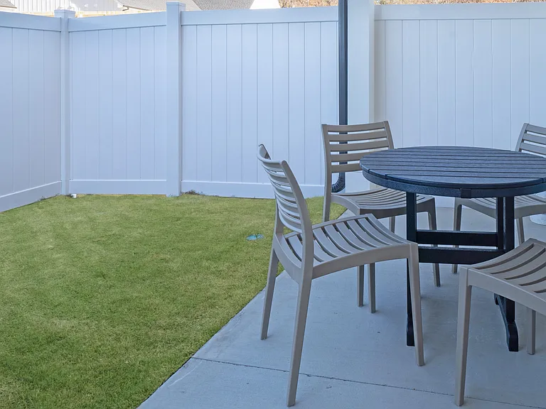 Covered back patio with fenced-in backyard