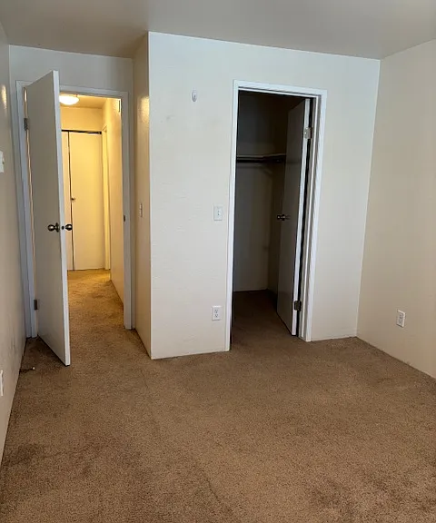 Primary bedroom in updated unit, with view of walk-in closet