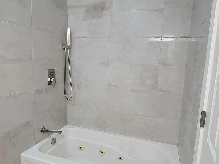 En-suite, primary bathroom with condo-quality waterfall shower, hand-held spray and a deep jacuzzi tub.