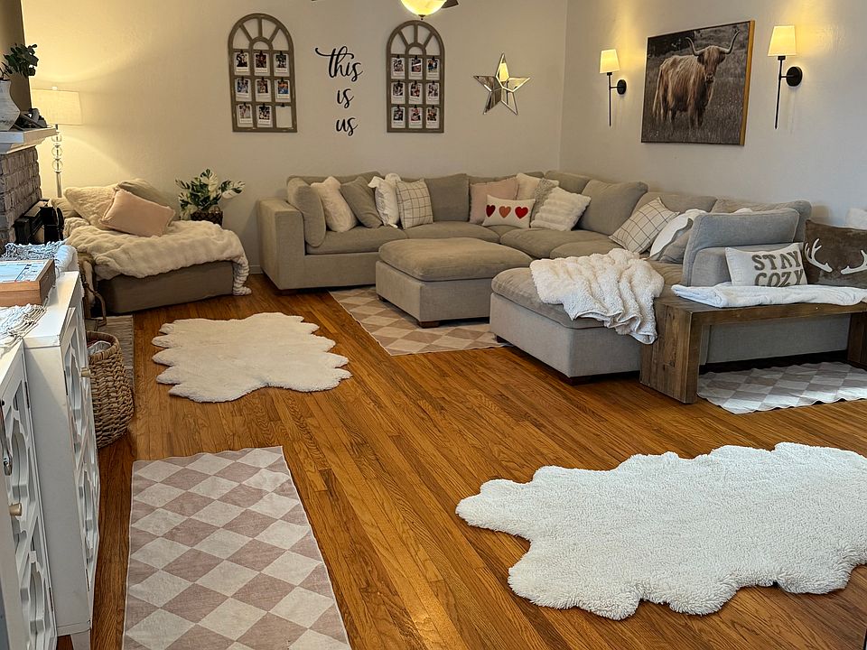 View from the front door into the large living room featuring a spacious front window with top-down/bottom-up blinds, ceiling fan, and wood floors.