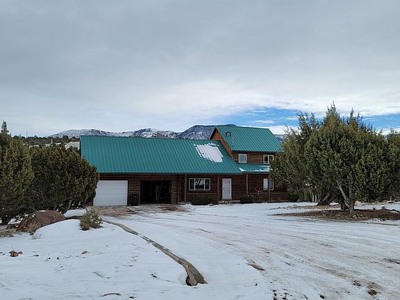 Front of house in winter with view of mountains