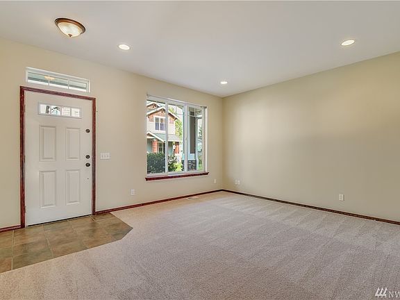 As you enter the home, you are welcomed by a bright and light living room with recessed lighting. 