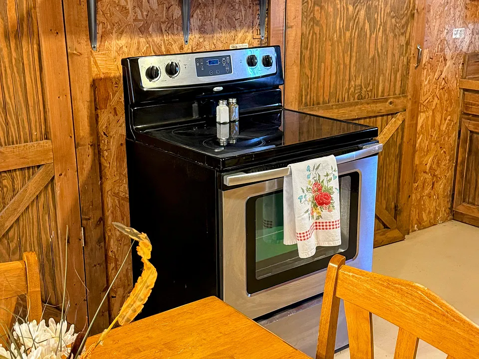 Close up of the glass top stove with the microwave above it.