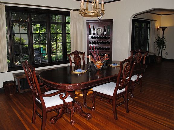 Expansive dining with arched entryway, built-ins, and double casted windows