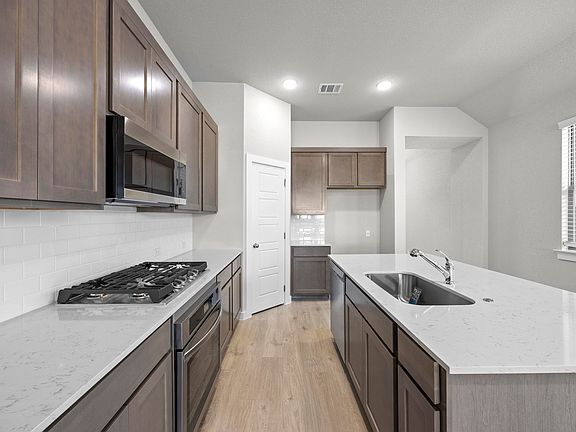 Kitchen in the Cedar home plan by Trophy Signature Homes - REPRESENTATIVE PHOTO
