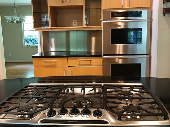 Five burner cooktop on granites island.