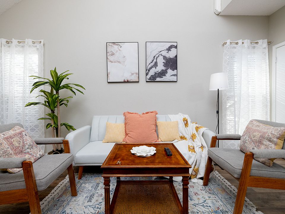 Cozy, spacious living room featuring a comfy couch, two chairs, a warm fireplace, TV, and a bookshelf stocked with books and games_perfect for relaxing or entertaining.