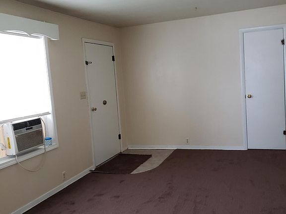 Living room looking at entry foor and coat closet and window ac.