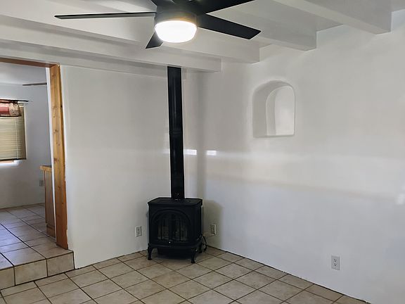 Cast iron gas fired stove provides the heat, It is connected to thermostat. Adds to the character of this adobe house. Living room fan helps with air circulation. Original niche on back wall.
