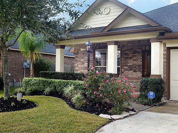 This provides a better view of the lush landscaping and the covered front Porch. Notice the detail moldings around the columns and the classic gas light in front.  There are also electrical outlets by the trees
