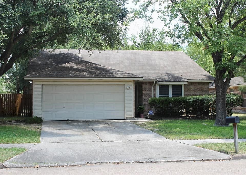 Traditional style home with mature tree lined front yard.