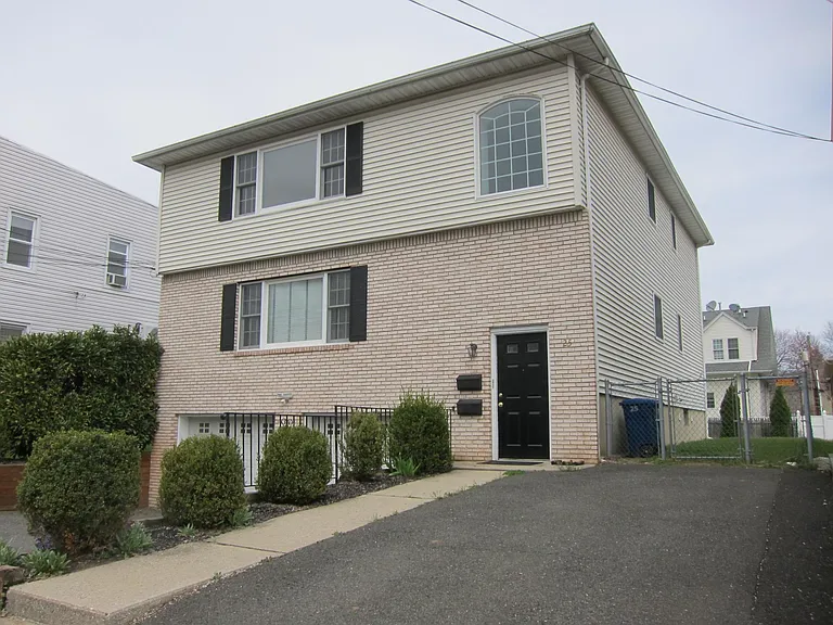 2 garage doors with additional parking in the front and a guest parking spot