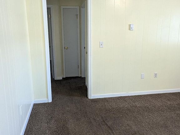 living room into hallway leading to bathroom and bedrooms