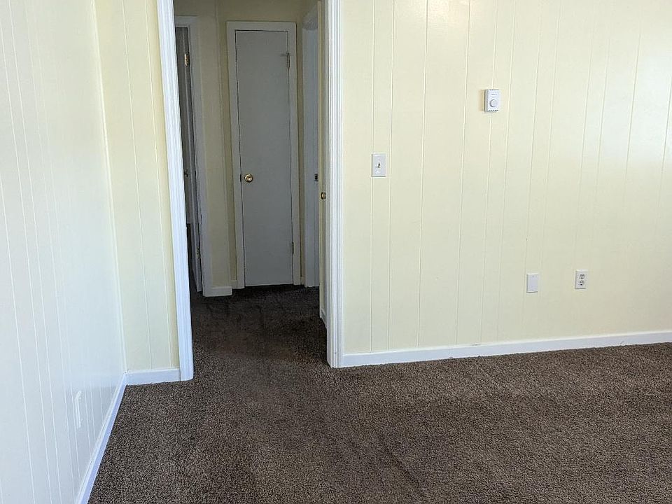 living room into hallway leading to bathroom and bedrooms