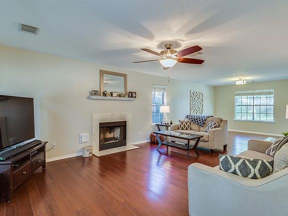 The spacious living area features wood flooring and a fireplace.