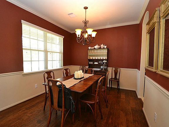 Dining room dazzled by crown molding, chair rails, hand scraped hardwood floors and access to the ki