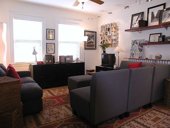 Inviting Living Room with custom wood blinds and track lighting