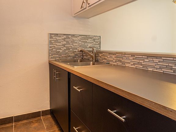 Kitchen counter space with cabinets below and above for storage. Double sink