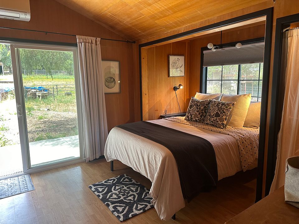 Main bedroom with queen bed, direct access to bathroom and private patio.