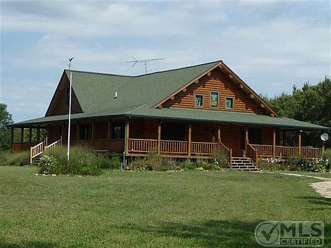 The Grass Lake log home is built with kiln dried whole logs and has a wrap around deck incorporating the Prarie Sytle architecture so appropriate to the setting.