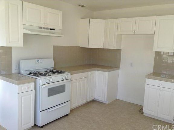 large kitchen, with lots of cabinets and counter space, stove and range hood