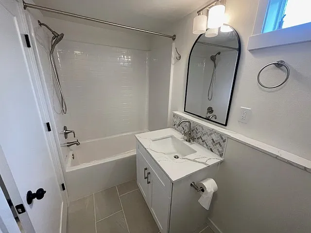 Large tub/shower with subway tile style surround and stainless fixures with removable hand held shower head
