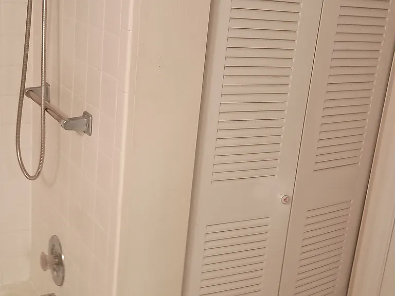 Linen closet by bathroom door that leads into bedroom.