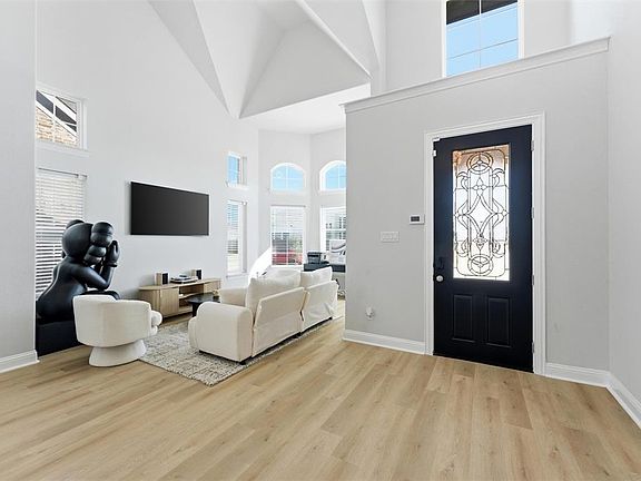 Entrance foyer featuring light wood-type flooring, plenty of natural light, and a high ceiling