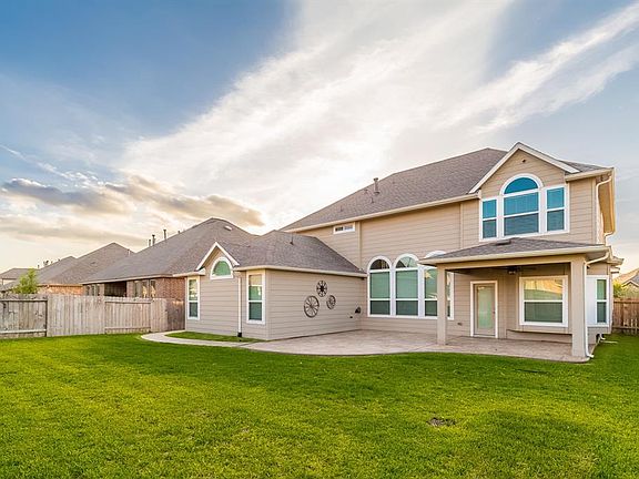 Custom stamped concrete walk way leads you back to a spacious backyard with covered patio and space to add a hot tub!