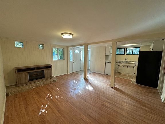 Living room with fireplace and kitchen, south view