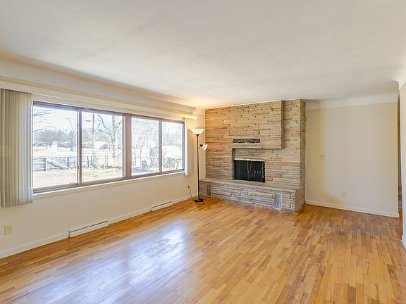 Family room with large windows and wood burning fireplace and wood floor.