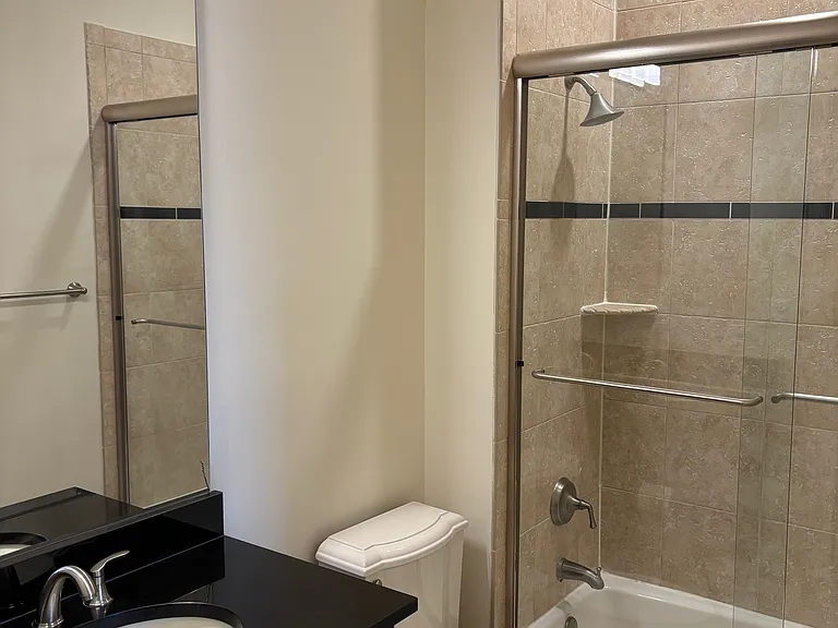Bath w/ Glass Enclosed Shower, Koehler Toilet and Large Vanity.