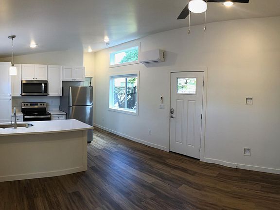 View of front door and kitchen with in-seating island, viewed from the living room.