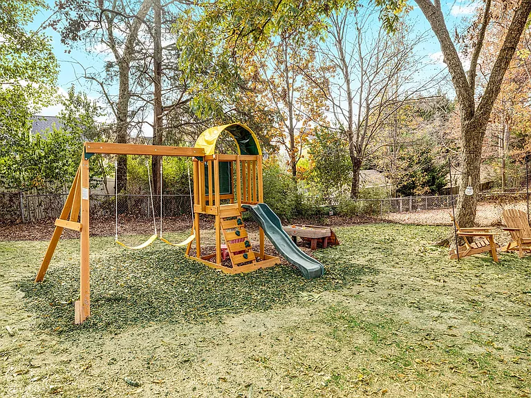 Play structure in fenced back yard