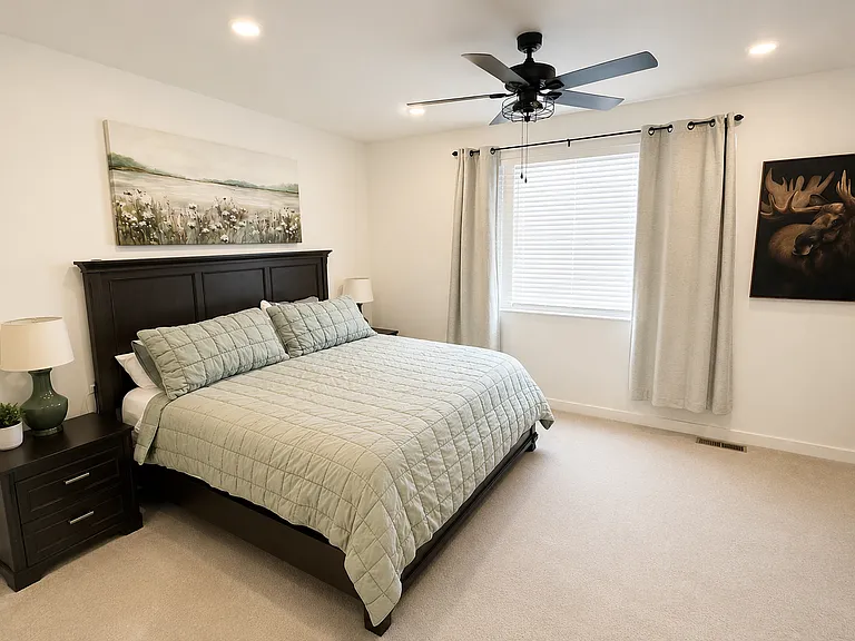 Large primary bedroom with walk-in closet, high ceilings and attached bathroom.