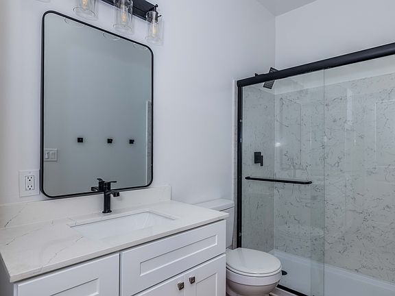 Bathroom with full bathtub, modern fixtures, and built-in vanity storage.