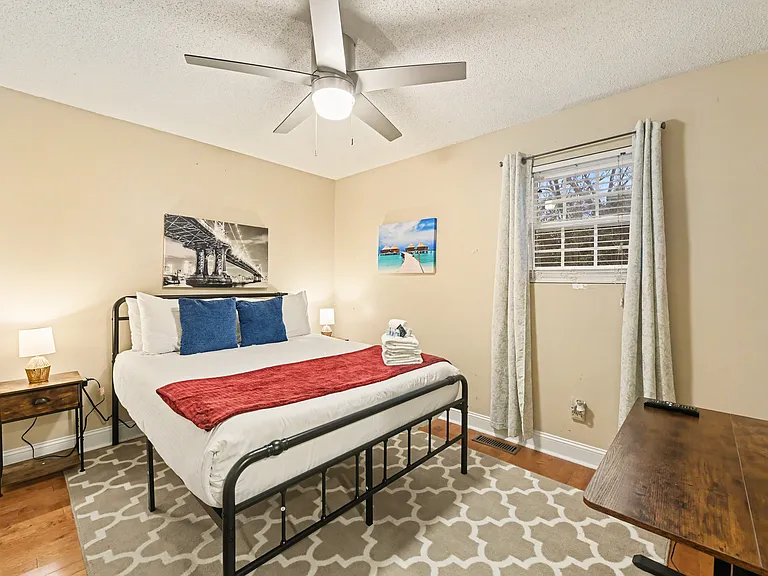 Bedroom 1 with queen bed, Smart TV, workspace with desk/chair, and large closet