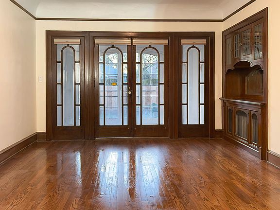 Dining room has vintage built-in hutch and Arts & Craft french doors that open to sunroom. Windows and doors sport new custom blinds.