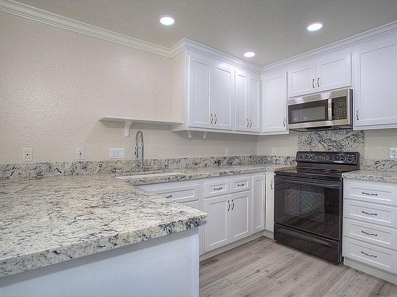 Bright and open kitchen with classic white cabinets, beautiful flooring and recessed lighting makes this kitchen perfect for all your cooking needs