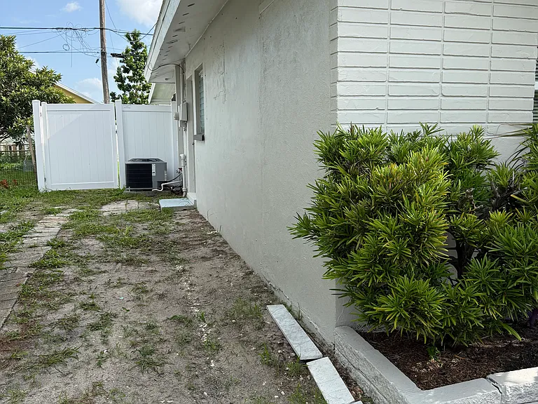 Left side of the house has a pathway that leads to a door that will go into the master bedroom. Then the ac and gate that opens to the back yard